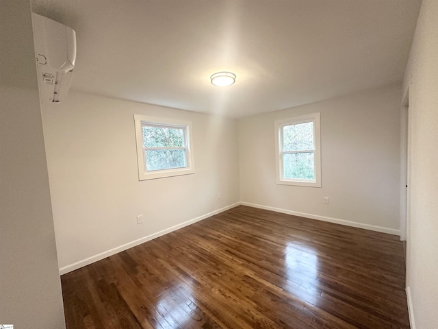 spare room with dark hardwood / wood-style flooring and a wealth of natural light