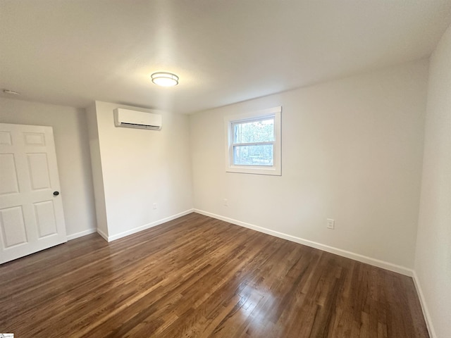 spare room featuring dark wood-type flooring and a wall mounted AC