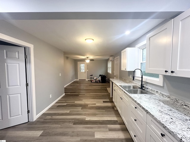 kitchen featuring hardwood / wood-style floors, white cabinetry, and sink