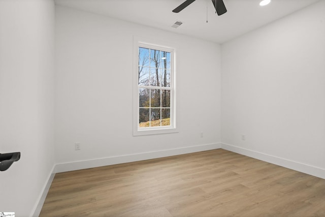 empty room with ceiling fan and light hardwood / wood-style flooring