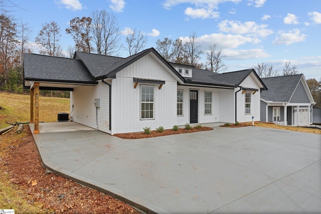 modern farmhouse style home featuring central AC unit and a carport