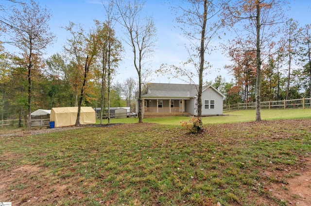 view of yard with covered porch and an outbuilding