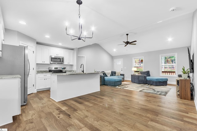 kitchen featuring white cabinetry, light hardwood / wood-style flooring, vaulted ceiling, a center island with sink, and appliances with stainless steel finishes