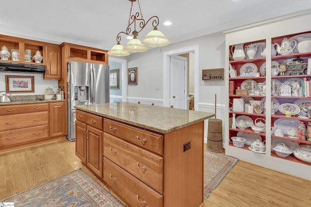 kitchen featuring a center island, stainless steel fridge with ice dispenser, pendant lighting, light hardwood / wood-style floors, and ornamental molding