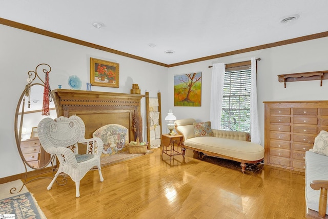 living area featuring crown molding and hardwood / wood-style flooring