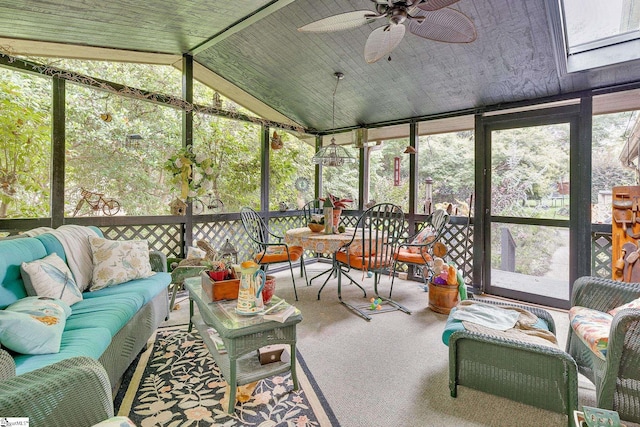 sunroom / solarium with ceiling fan and vaulted ceiling with skylight