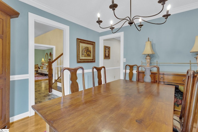 dining area with an inviting chandelier, light hardwood / wood-style flooring, and ornamental molding