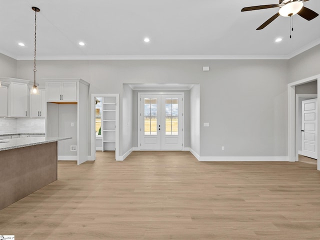 unfurnished living room featuring french doors, light wood-type flooring, ceiling fan, and crown molding