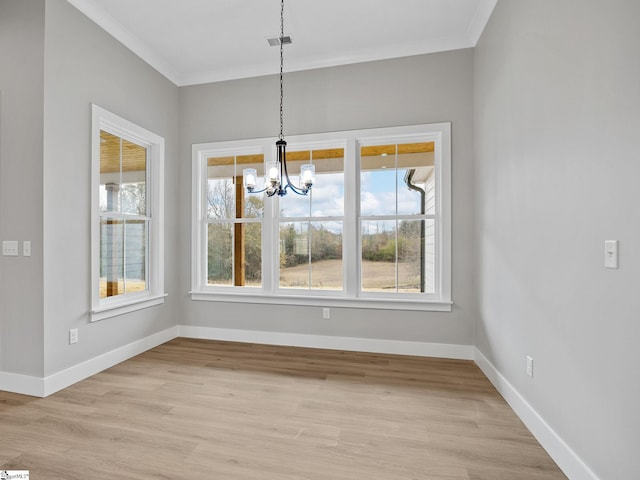 unfurnished dining area with plenty of natural light, ornamental molding, and light wood-type flooring