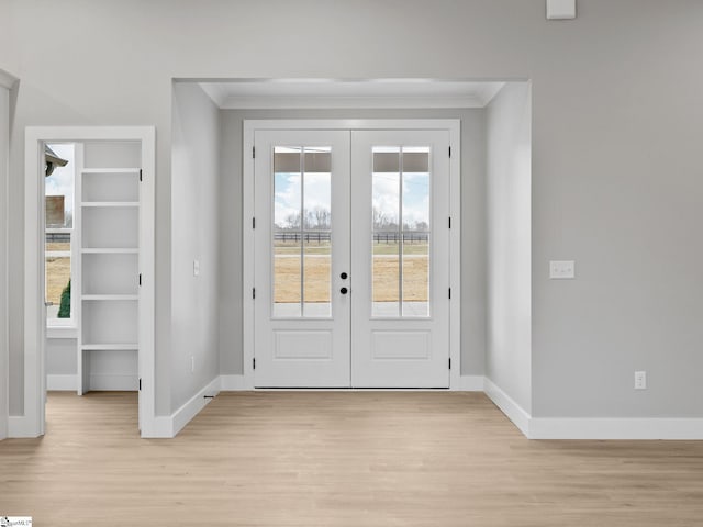 doorway to outside with french doors, light hardwood / wood-style floors, and ornamental molding