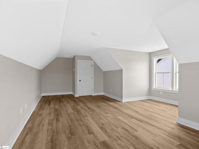 bonus room featuring vaulted ceiling and light hardwood / wood-style flooring