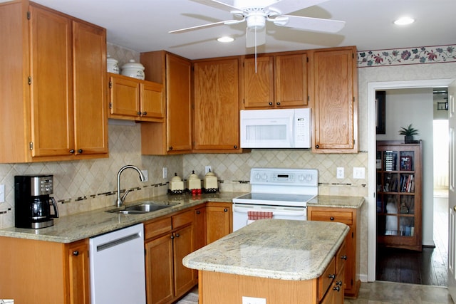 kitchen with white appliances, a center island, backsplash, and sink