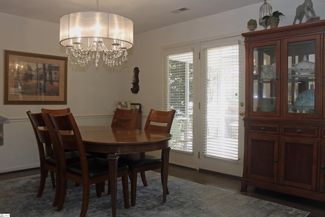 dining room with dark hardwood / wood-style floors and an inviting chandelier