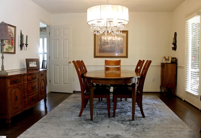 dining space with dark hardwood / wood-style floors and a chandelier