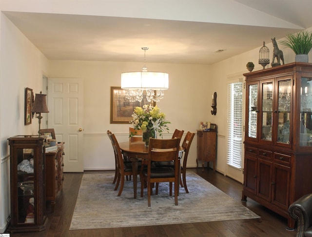 dining room featuring a chandelier and dark wood-type flooring