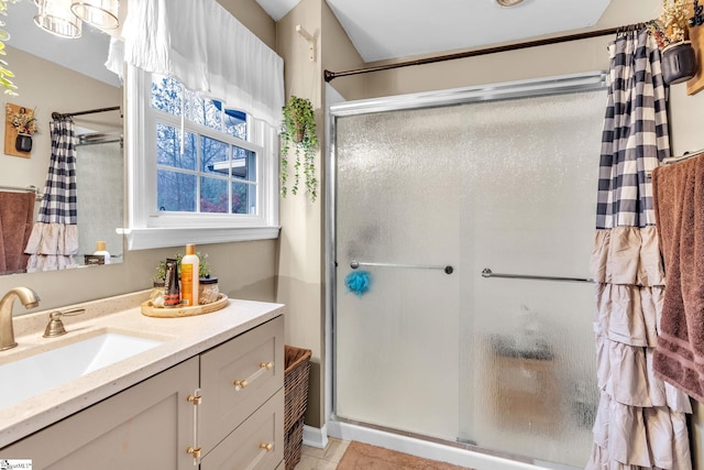 bathroom with tile patterned flooring, vanity, and walk in shower