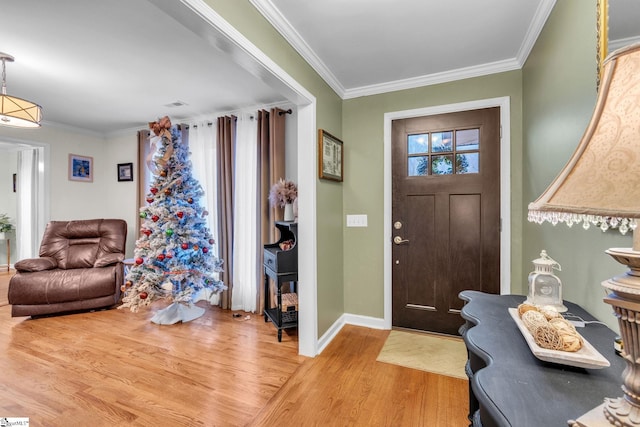 foyer with crown molding and light wood-type flooring