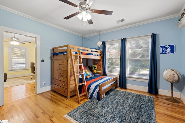 bedroom with hardwood / wood-style flooring, ceiling fan, and ornamental molding