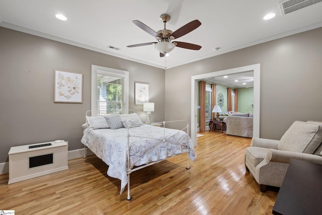 bedroom featuring ceiling fan, light wood-type flooring, and crown molding