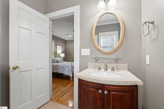 bathroom with a healthy amount of sunlight, vanity, hardwood / wood-style flooring, and crown molding