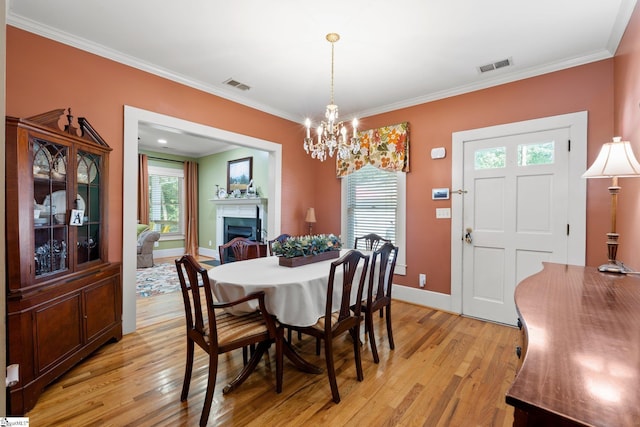 dining room featuring light hardwood / wood-style flooring, a notable chandelier, and ornamental molding