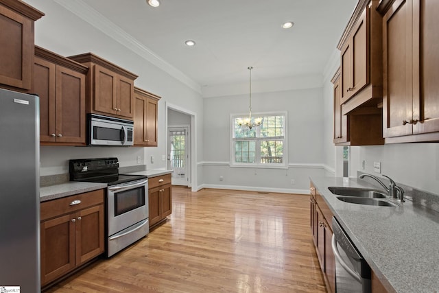 kitchen featuring ornamental molding, stainless steel appliances, sink, an inviting chandelier, and light hardwood / wood-style flooring