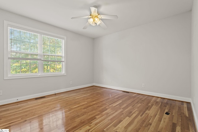 spare room with ceiling fan and light wood-type flooring