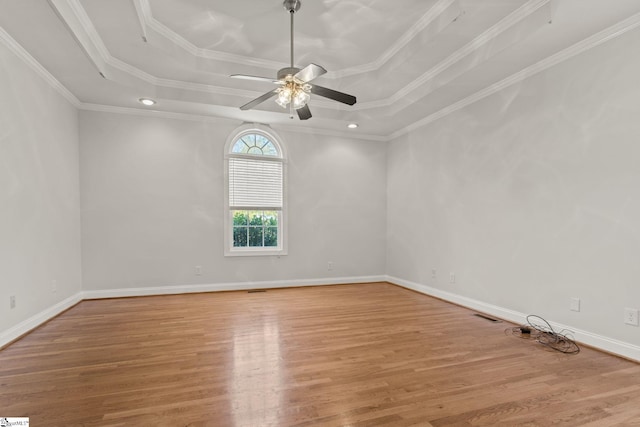 spare room with ceiling fan, light hardwood / wood-style floors, a raised ceiling, and crown molding