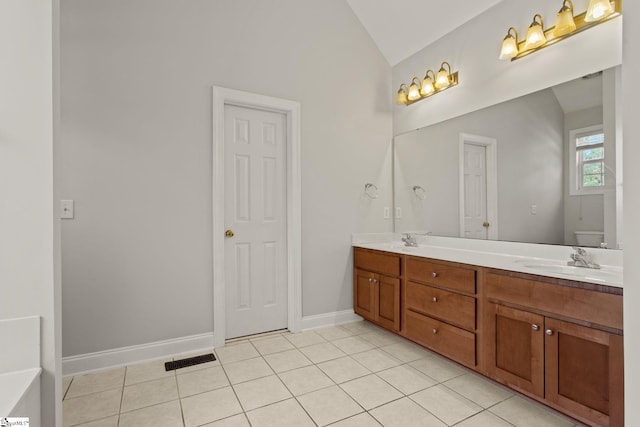 bathroom featuring tile patterned flooring, vanity, vaulted ceiling, and toilet