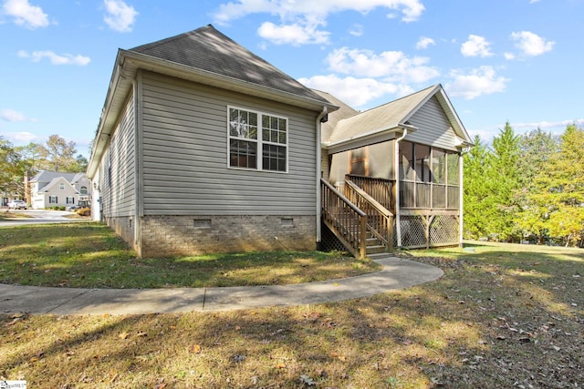 view of side of property featuring a sunroom and a lawn