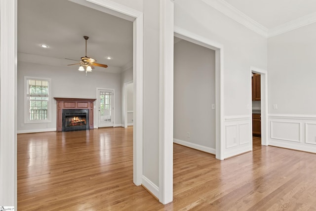 unfurnished living room with light hardwood / wood-style flooring, ceiling fan, and ornamental molding