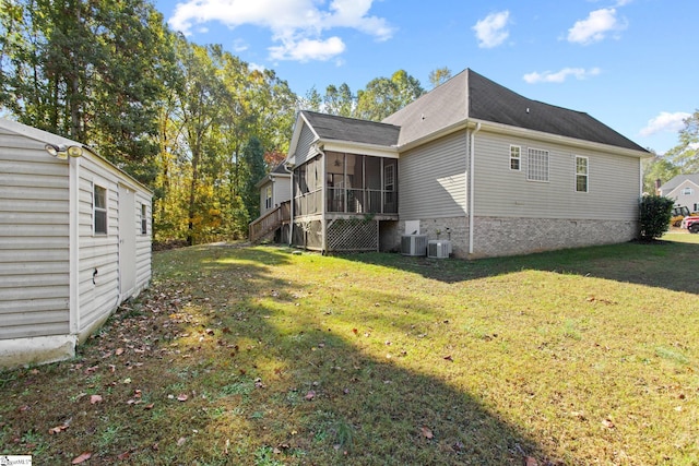 exterior space with a lawn, a sunroom, and cooling unit