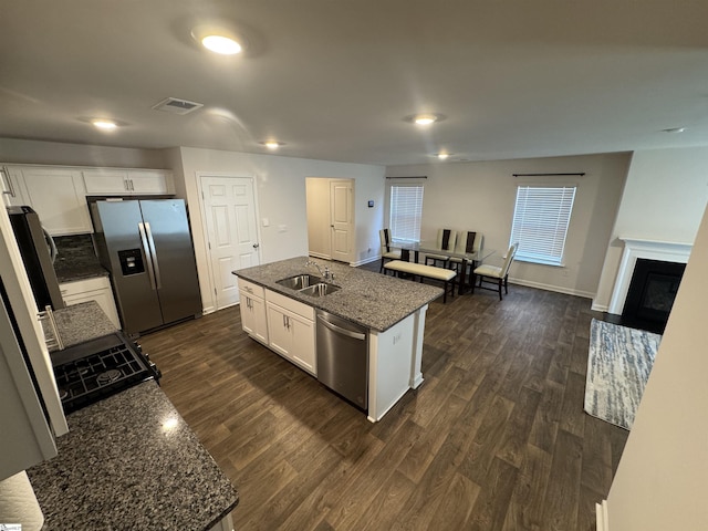 kitchen featuring appliances with stainless steel finishes, a kitchen island with sink, sink, white cabinets, and dark hardwood / wood-style floors