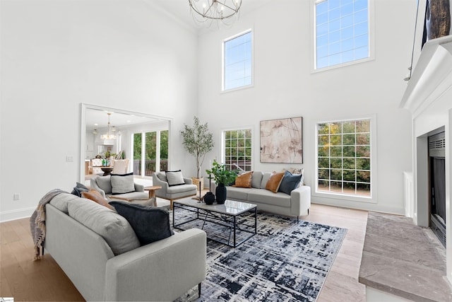 living room featuring hardwood / wood-style floors, a chandelier, and a high ceiling