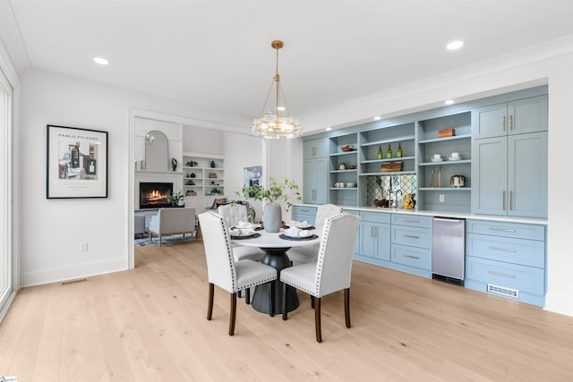 dining room with built in features and light wood-type flooring