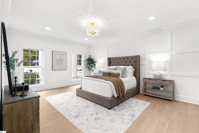 bedroom featuring a chandelier, light hardwood / wood-style floors, and ornamental molding