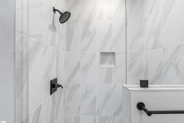 interior details featuring a tile shower