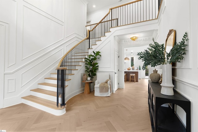 interior space with ornamental molding and parquet flooring