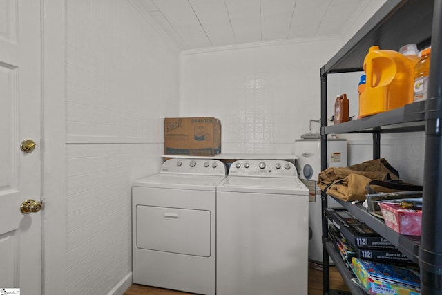 laundry area featuring water heater, washer and clothes dryer, hardwood / wood-style flooring, and ornamental molding