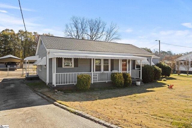 bungalow-style house featuring a front yard, a porch, and a carport