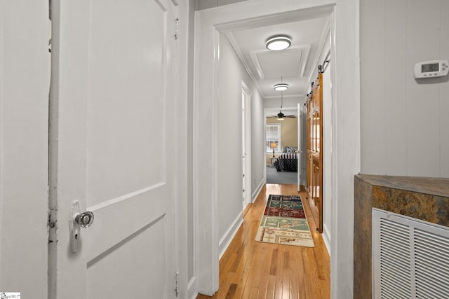 hallway with light wood-type flooring and ornamental molding