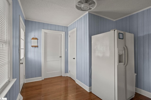 corridor featuring wood-type flooring, a textured ceiling, and crown molding