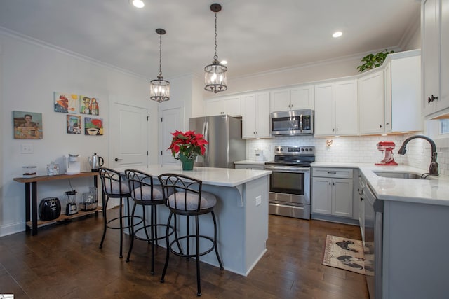 kitchen featuring white cabinetry, dark hardwood / wood-style flooring, a kitchen island, and appliances with stainless steel finishes