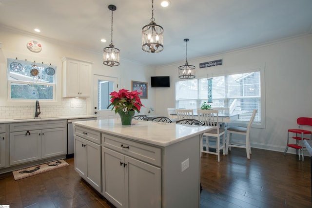 kitchen with decorative light fixtures, a kitchen island, dark hardwood / wood-style flooring, and sink