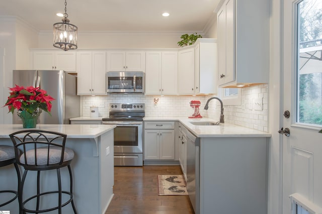 kitchen with appliances with stainless steel finishes, white cabinetry, a healthy amount of sunlight, and sink