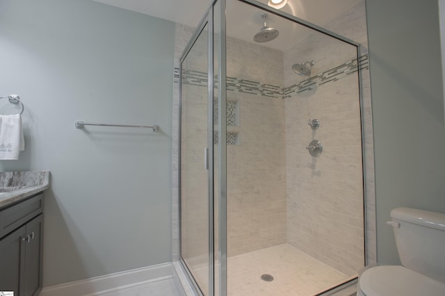 bathroom with a shower with door, vanity, and toilet