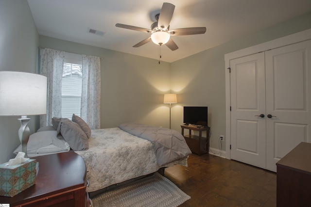 bedroom with ceiling fan, a closet, and dark wood-type flooring