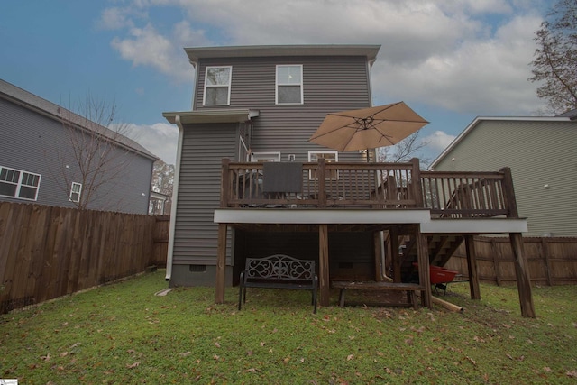 back of property featuring a lawn and a deck