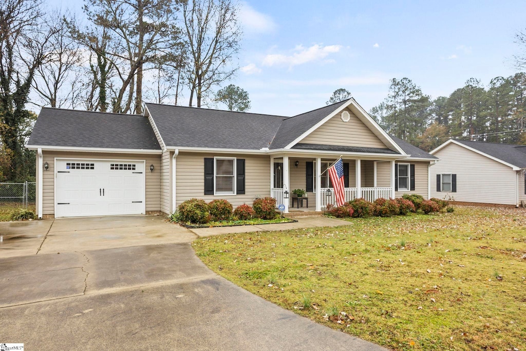 ranch-style home with covered porch, a garage, and a front lawn