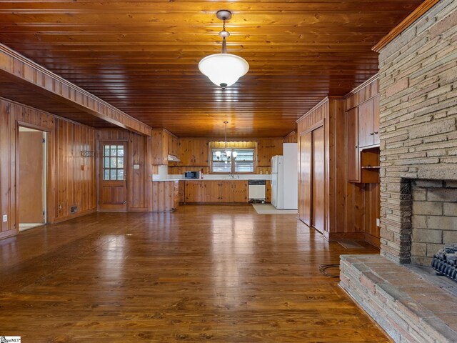 unfurnished living room featuring wooden ceiling, a stone fireplace, dark hardwood / wood-style flooring, wood walls, and a chandelier